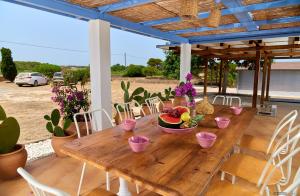 米乔尔海滩Casa Ca Na Quina Migjorn Formentera的庭院里的木桌,上面有水果
