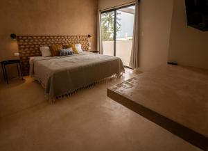 德尔奇亚港Casa Arrayan Telchac的一间卧室设有一张大床和一个大窗户