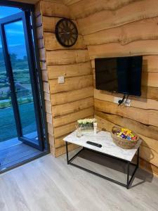 BannvaleGreenview Glamping Pods的一间设有墙壁、时钟和桌子的房间