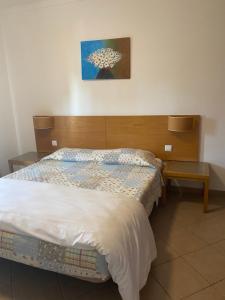 波尔蒂芒卡斯特罗达罗沙公寓的一间卧室配有一张带木制床头板的床