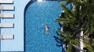 马拉戈日Árvo Boutique Hotel的一位女士在度假村的游泳池里
