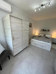 扎马迪Mira apartman的一间卧室配有一张床和一个大衣柜