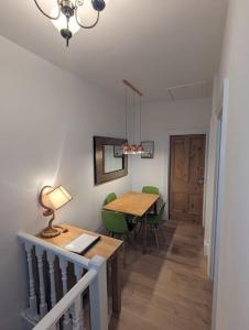 托基Spacious first floor family flat, Sea view的一间带桌子和绿色椅子的用餐室