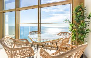 贝尼多姆INTEMPO SKY RESORT by Costa Activa Rentals的海景阳台上的桌椅