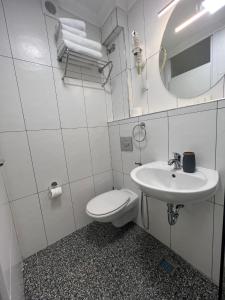 萨拉热窝Amber Hotel的白色的浴室设有卫生间和水槽。