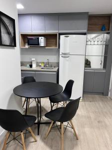 巴乌鲁Apartamento Bauru的厨房配有桌椅和冰箱。