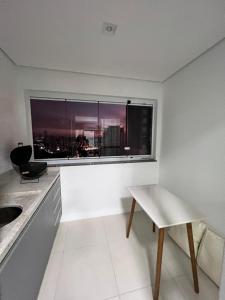 巴乌鲁Apartamento Bauru的厨房设有窗户、桌子和椅子