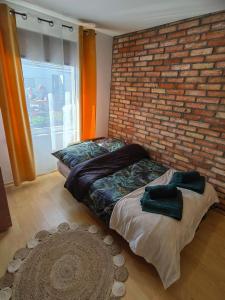 ŻarnowskaSiedlisko PoMaLeńku的一间卧室设有砖墙和一张床