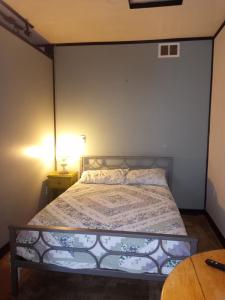 Happy CampBigfoot RV & Cabins Park的一间卧室配有一张床和一张带台灯的桌子
