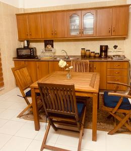 马达巴Laura's Cozy HOME的厨房配有木制橱柜和木桌及椅子