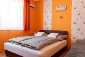 博加奇Piknik Vendégház的橙色墙壁和窗户的房间里一张床位