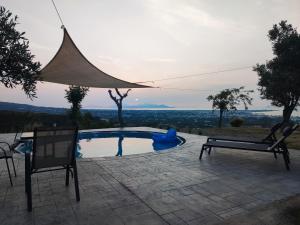 帕萨里迪Yiorgos, amazing sunset view house的一个带桌子和两把椅子的游泳池