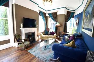 巴克斯顿The Huntress Suite的客厅设有蓝色的沙发和壁炉