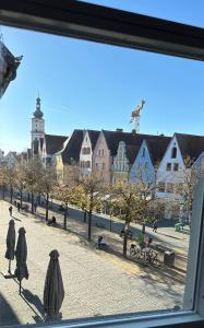 魏登Eigentumswohnung Altstadt Weiden的从带遮阳伞的街道窗户欣赏风景