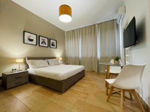 卡塔尼亚Le Dimore del Corso的一间卧室配有一张床、一张桌子和一台电视