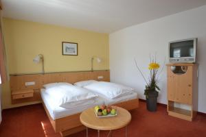 萨尔茨堡科尔彼得酒店的一间卧室配有一张床和一张桌子及一碗水果