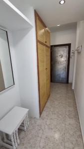 El AlquiánApartamento en Costacabana的走廊上的门和房间中的长凳