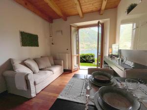 拉利奥Regina di Laglio - Free Parking, Garden, Lake View的客厅配有沙发和桌子
