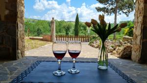 圣焦万尼达索VAL D'ORCIA DELUXE 3, incantevole casa con vista sulle colline, WiFi e parcheggio的两杯酒坐在桌子上,带花瓶