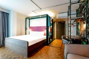 曼彻斯特YOTEL Manchester Deansgate的一间卧室配有一张床和一把椅子