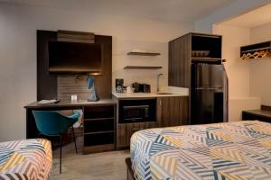 大章克申Studio 6 Grand Junction, CO的酒店客房配有一张床、一张书桌和一间厨房。