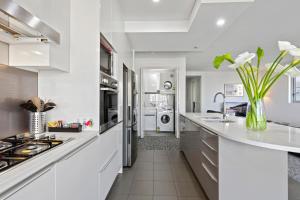 悉尼AAN Apartments North Sydney的白色的厨房配有白色的柜台和水槽