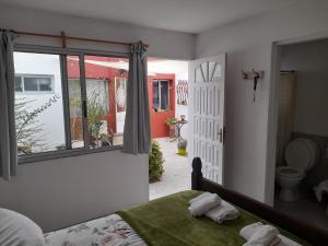 科洛尼亚-德尔萨克拉门托Posada Mela的一间卧室设有一张床、一个窗口和一间浴室