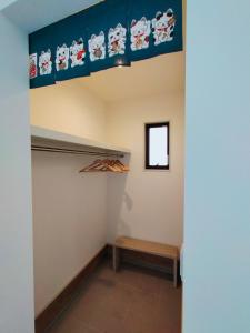 名古屋FunHome黒川的一间设有架子和天花板下长凳的房间