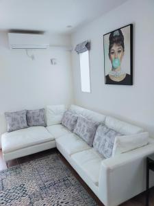 名古屋FunHome黒川的白色的客厅配有白色的沙发和绘画作品