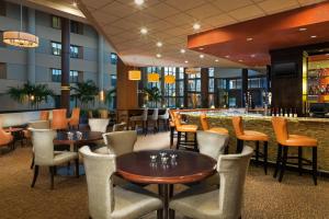 夏洛特夏洛特机场喜来登酒店 的一间带桌椅的餐厅和一间酒吧