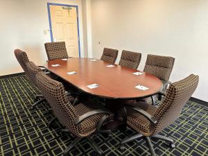 韦恩堡Travelodge by Wyndham Fort Wayne North的一间会议室,配有木桌和椅子