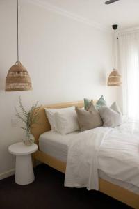 塔南达The Beech House-Hill views, peaceful location, 2BR的一间卧室配有带白色床单和枕头的床。