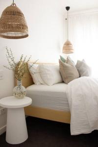 塔南达The Beech House-Hill views, peaceful location, 2BR的一张带白色枕头的床和一张桌子