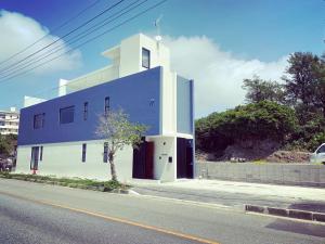 吉马Sky Blue Villa沖縄的街道边的蓝色和白色建筑