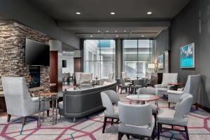 多伦多多伦多机场喜来登会议中心酒店的一间设有桌椅和电视的等候室