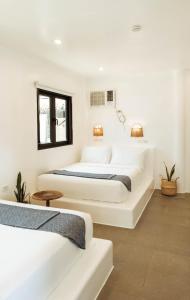 卢纳将军城Hostel Bajala Siargao的白色墙壁客房的两张床