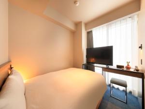 福冈QuintessaHotel FukuokaHakata Relax&Sleep的一间卧室配有一张床和一台平面电视
