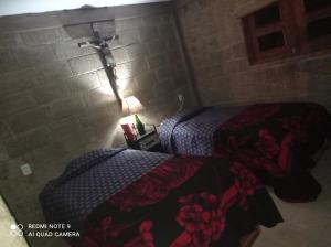 Cómoda casita de campo的一间卧室设有两张床和砖墙