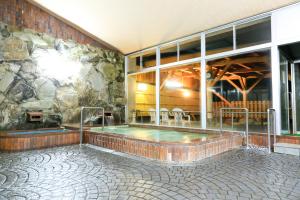 京丹后市大桥探戈温泉旅馆的一座石头墙建筑中的热水浴缸