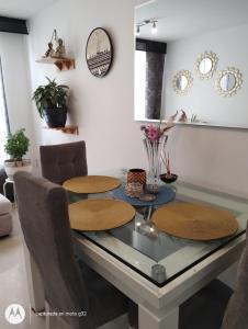 波哥大Apartamento sector exclusivo acogedor的一间设有玻璃桌和椅子的用餐室