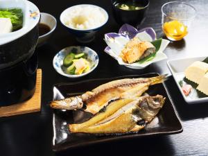 京丹后市大桥探戈温泉旅馆的餐桌,上面有一盘食物,包括鱼和其他菜肴
