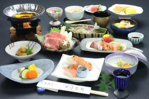 高山田边旅馆的一张桌子上放着许多盘子的食物