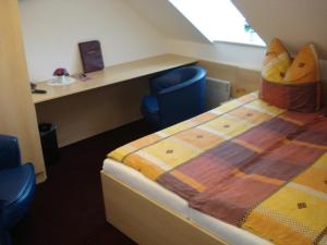 桑格豪森比尔森图布酒店的客房设有一张床、一张桌子和一把椅子。