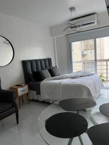 布宜诺斯艾利斯Buenos Aires City的卧室配有床、椅子和窗户。