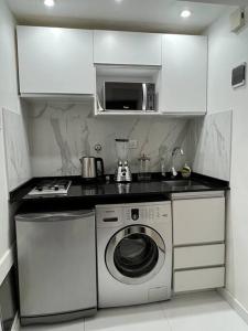 布宜诺斯艾利斯Buenos Aires City的厨房配有洗衣机和微波炉。