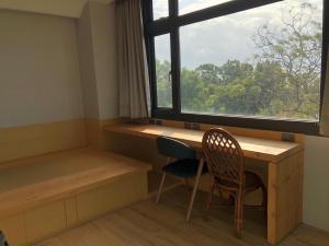 东河La Tree 普椿農場木子莊園的客房设有书桌、窗户和椅子。