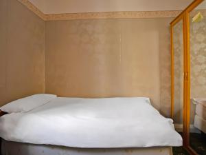 伊普斯威奇Great White Horse Hotel的一张铺有白色床单和木架的床