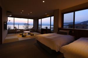 诹访市Suwakoen的一间带两张床的卧室,享有海景