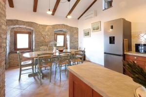 伊齐齐Villa Fani with Jacuzzi的厨房以及带桌子和冰箱的用餐室