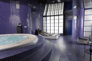 玛丽亚温泉Hotel Morris Relax & Wellness的浴室配有蓝色瓷砖浴缸